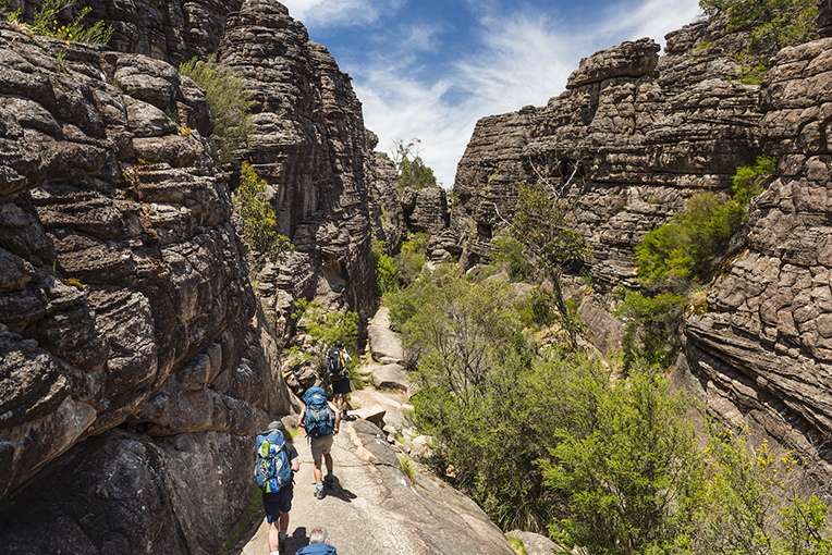 A group of people hiking through the beautiful canyons of Grampians in Victoria.